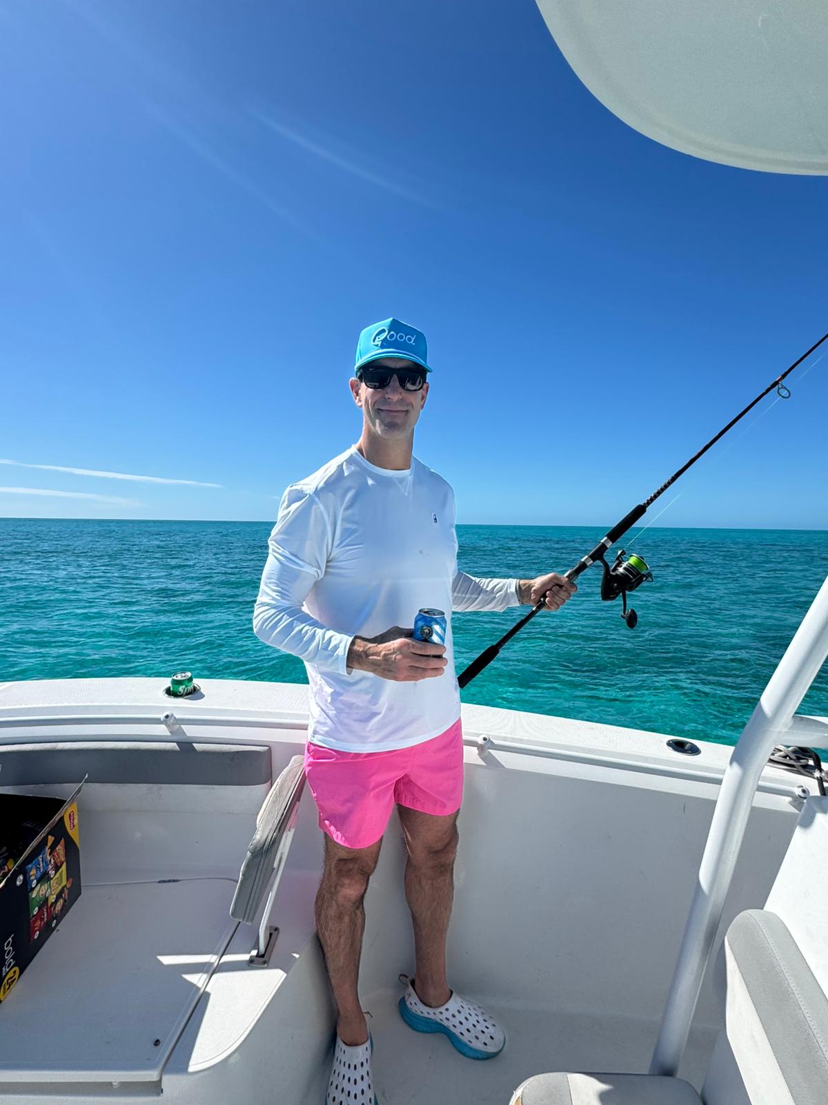 Guest fishing on deck over deep blue water