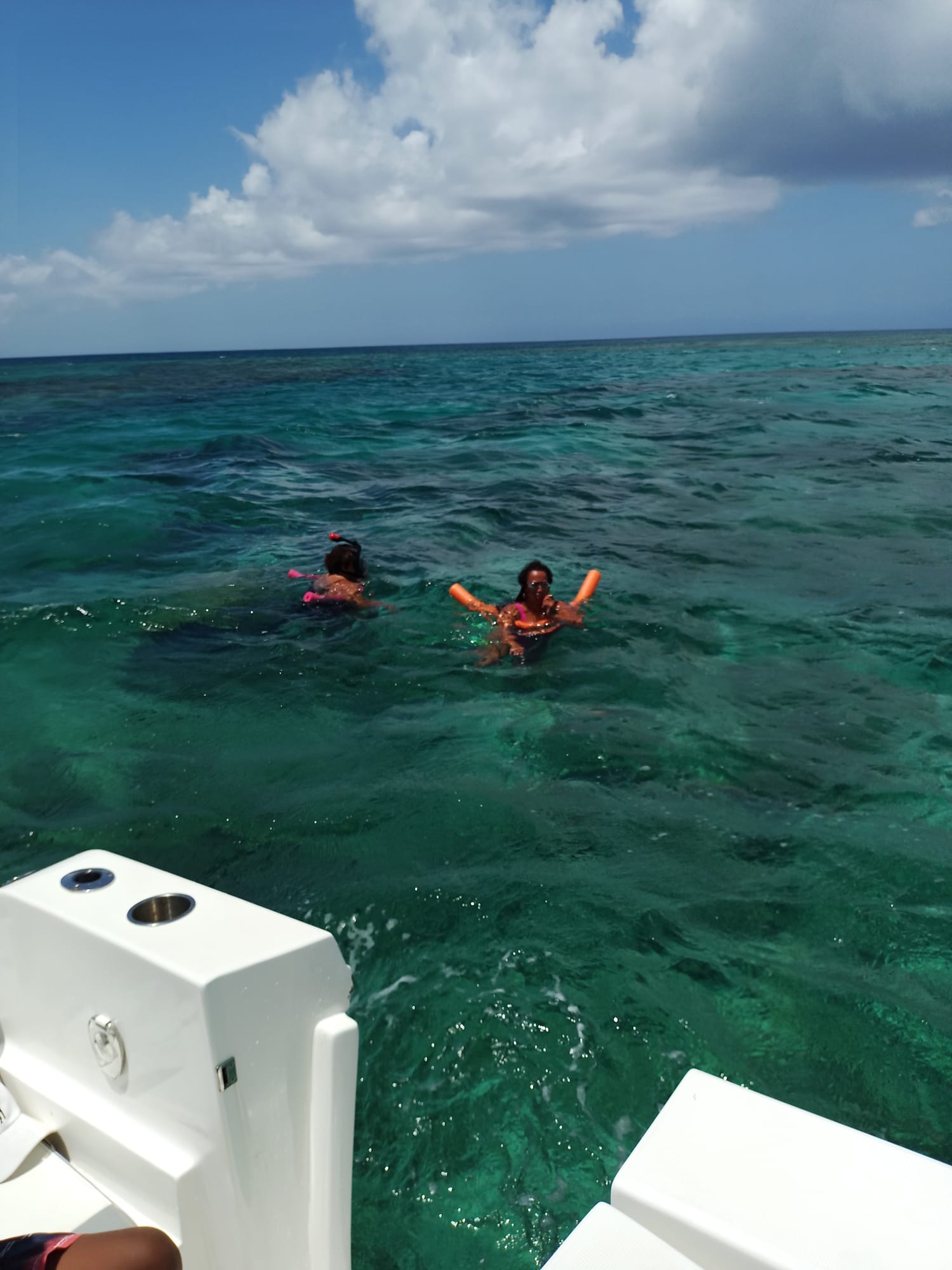 Snorkelers floating over a turquoise reef