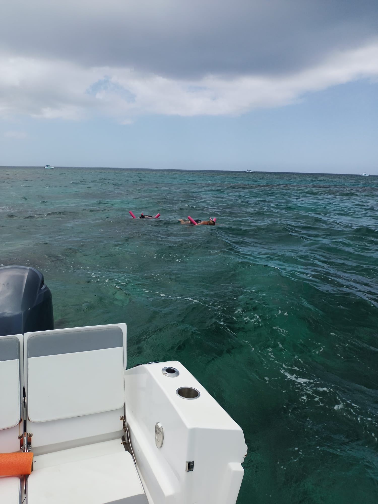 Snorkelers drifting behind the boat over the reef